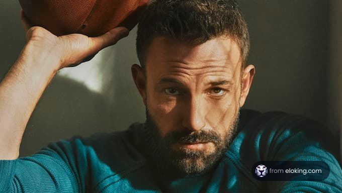 Ben Affleck holding a football in a striking portrait.