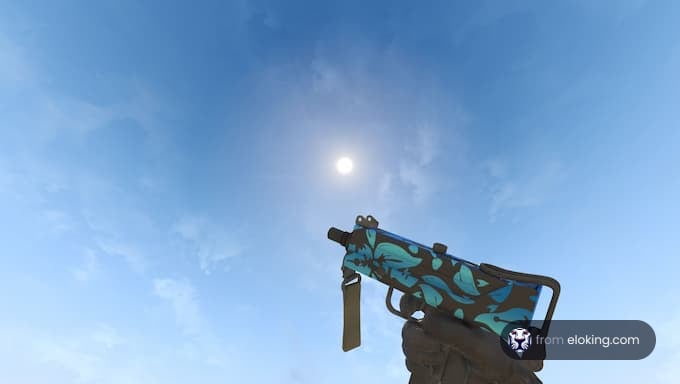 A colorful handgun pointed towards the sky with sunshine in the background