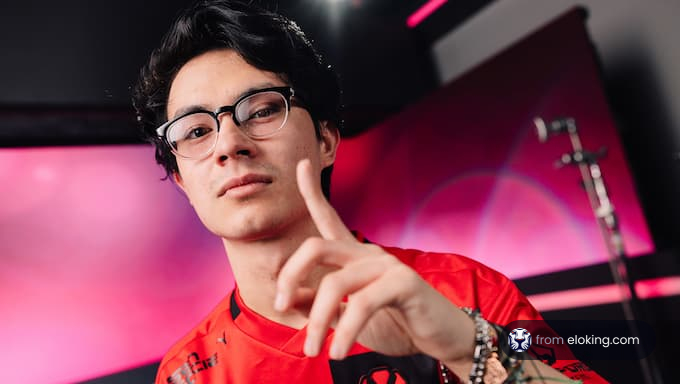 Confident young man in glasses and red jersey pointing at the camera