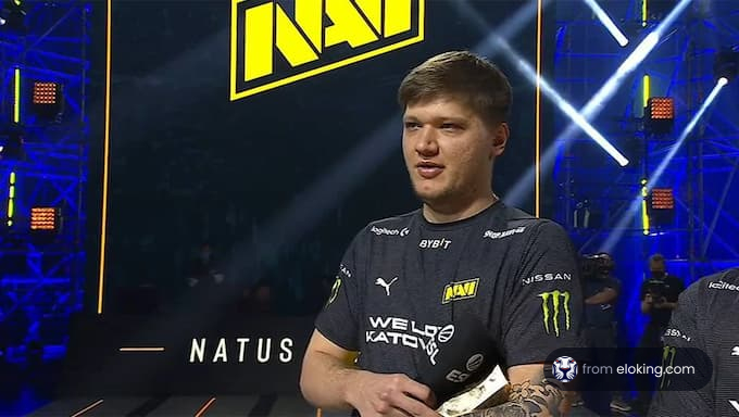 eSports player speaking at an event with Natus Vincere logo in the background