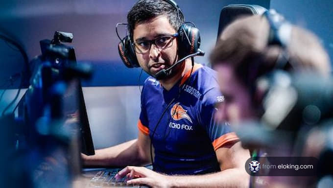 A focused esports player wearing headphones and a team jersey