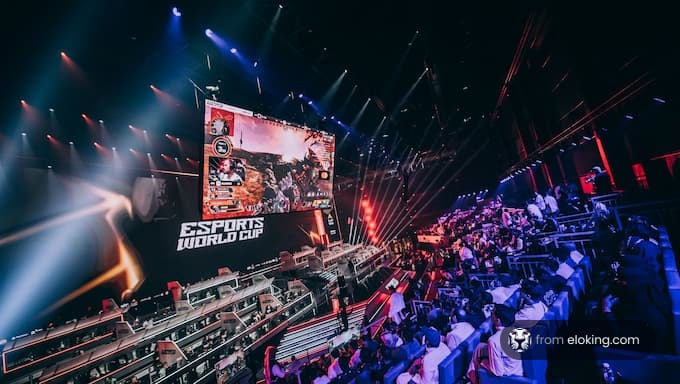 A vibrant scene from the Esports World Cup with a large screen and an enthusiastic audience.