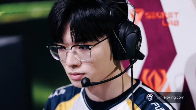 A focused gamer wearing a headset at an esports event
