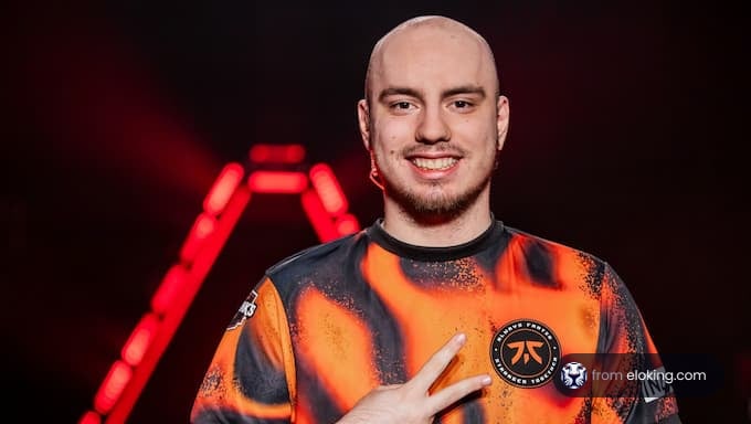 A smiling esports player in a vibrant gaming jersey poses for a portrait.