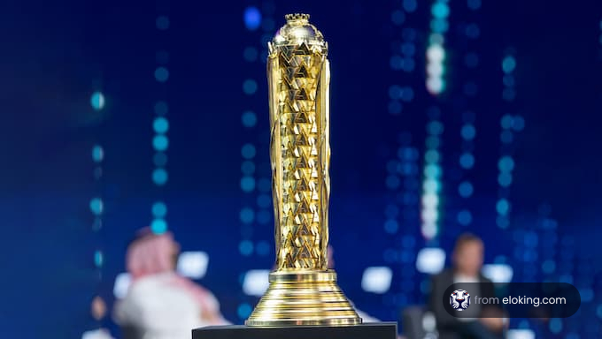 Golden trophy at an award ceremony with a blurred audience and blue lights in the background