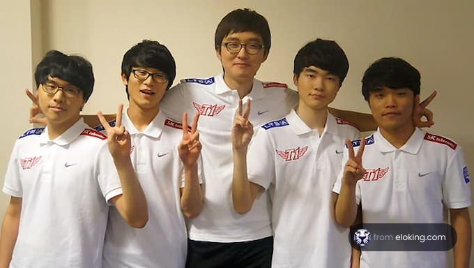 Group of five young men in matching white shirts posing with peace signs