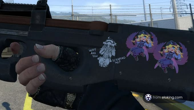 Hand holding a customized gun decorated with cartoon stickers