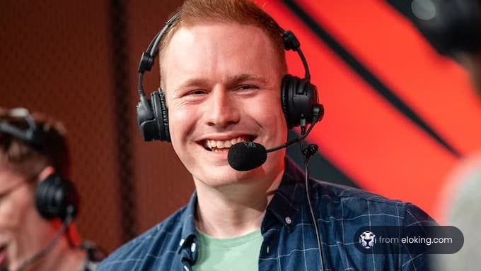 A smiling gamer commentator with headphones