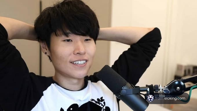 A happy gamer smiling while seated at a desk.