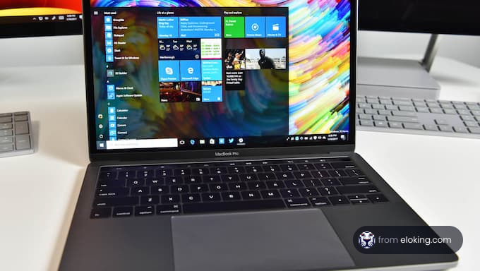 A MacBook Pro displaying a Windows interface with colorful background.