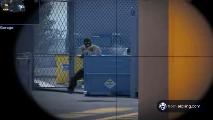 Man sitting by a blue container near a fence in an industrial area