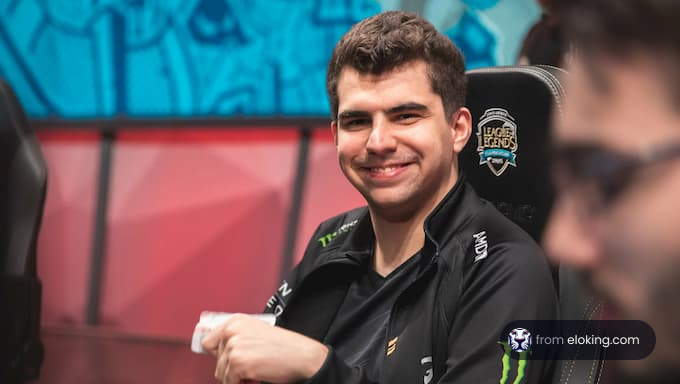 A smiling League of Legends player in a gaming chair.