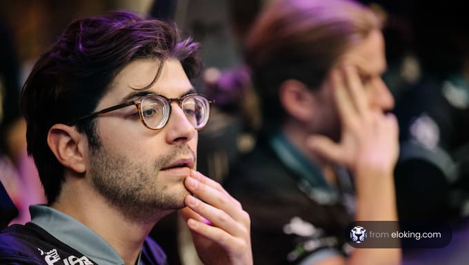 A thoughtful gamer at an esports event contemplating the game.