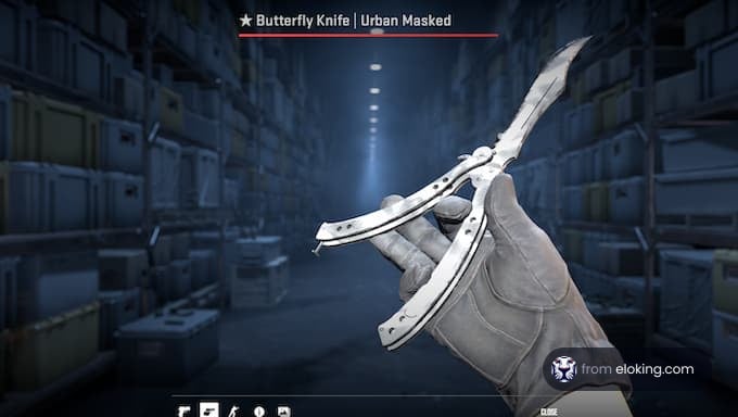 Hold of a butterfly knife with an urban mask design in a warehouse