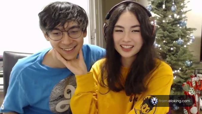 Young couple smiling during a video call with a Christmas tree in the background