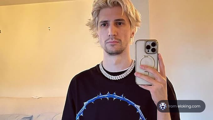 Young man with blonde hair taking a selfie in mirror